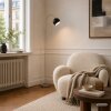 Brilliant Bogenleuchte Helen mit schwarzem Halbkugelschirm neben dem Sofa im modernen Stil
